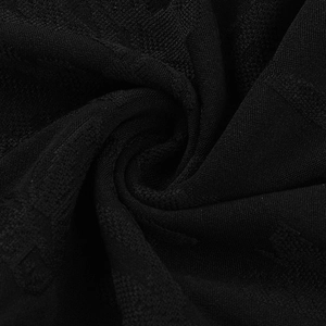 Detailed macro view of black knit fabric texture showing regular ribbed weave structure