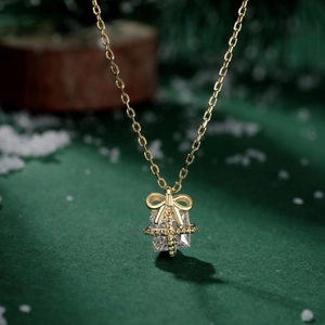 Macro shot of gold gift box pendant with square zircon on a festive winter background