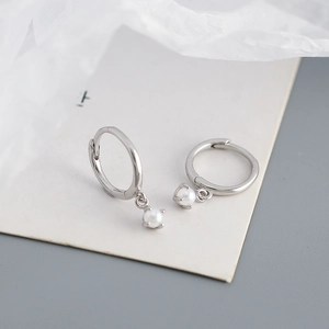 Macro view of minimalist s925 silver hoop earrings with elegant white pearl drops