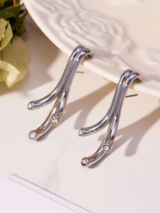 Vue détaillée des boucles d'oreilles branche en argent avec zircons sur une assiette
