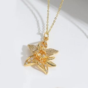 Macro shot of gold flower pendant necklace with white zircons on minimalist chain