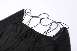 Détail des manches en maille et des lacets sur une robe moulante noire pour femmes