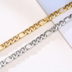 Detail view of gold and silver Figaro chains with polished links for layering