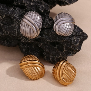 Dettaglio di orecchini ovali intrecciati vintage in finiture oro e argento