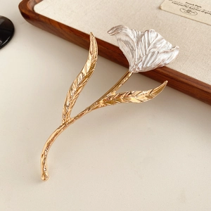 Detailed close-up of a tulip brooch featuring gold brushed metal and pearl-like petals