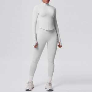 Dettaglio della giacca da yoga grigia con zip e fori per i pollici e leggings abbinati