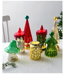 Detail of Christmas LED lights set with mini glass trees and candles on snow