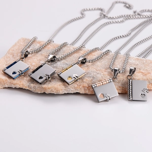 Book-shaped heart necklaces in five metallic colors displayed on a beige stone