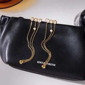 Golden stainless steel tassel earrings featuring three cubic zirconia stones and long chains