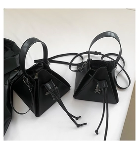 Detail of black punk style triangular bags featuring silver skull and chain decorations