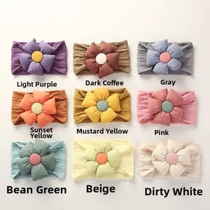 Detail of nine knitted baby headbands with 3D fabric flowers in various pastel colors