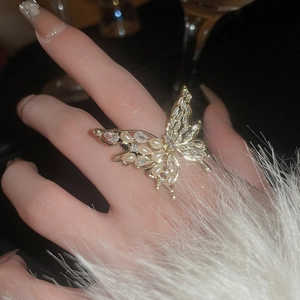 Close-up of golden butterfly ring with pearls and zircon on model with fur cuff