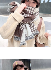 Detail of a brown and beige checkerboard scarf with soft knit texture and fringe tassels