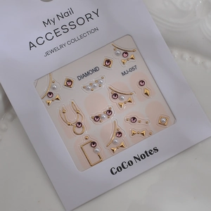 Detail view of MJ-057 nail art charms with pink rhinestones and gold metal accents