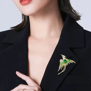 Elegant Chinese style phoenix brooch with green enamel and gold finish on model