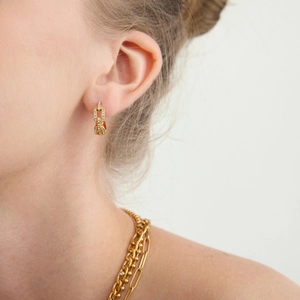 Boucles d'oreilles chaînettes dorées avec zircons blancs brillants sur mannequin