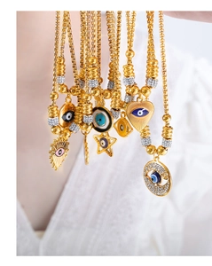 Detailed close-up of vintage gold evil eye charms with blue enamel and rhinestones
