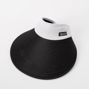 Détail de l'étiquette brodée blanche sur une visière pare-soleil noir et blanc à large bord