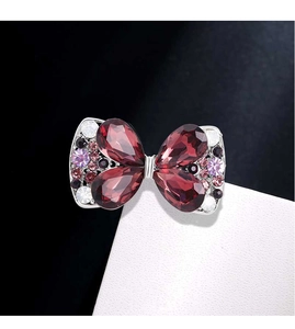 Macro shot of wine red crystal bow brooch with sparkling rhinestones and silver setting