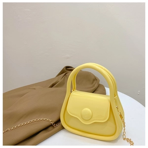 Macro shot of a yellow mini jelly bag with a polished golden metal chain strap