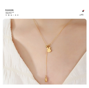 Detail of golden Y-shaped adjustable necklace featuring cute rabbit and carrot pendants
