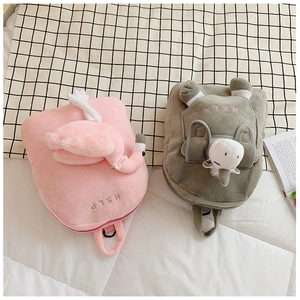 Detailed view of pink flamingo and green unicorn plush backpacks with HSLP embroidery
