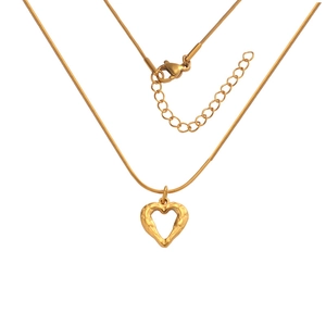 Detail of golden heart-shaped pendant with texture on a delicate snake chain