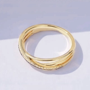 Makroaufnahme des goldenen Kreuzrings mit mikrogefassten Zirkonia-Akzenten