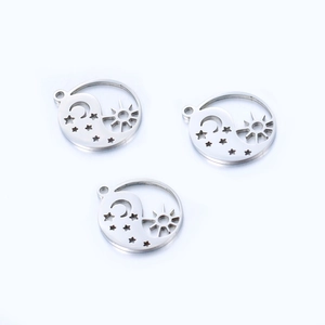 Detail view of three stainless steel charms featuring sun, moon, and tai chi cutouts