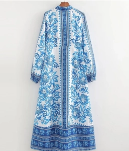 Detailed view of blue and white floral patterns on a bohemian long-sleeved dress