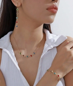 Détail d'une parure dorée avec zircons multicolores en forme de cœur sur mannequin