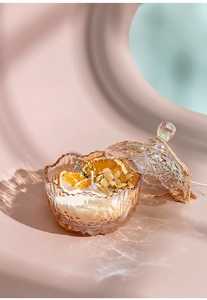 Macro detail of amber glass candle jar with embossed texture and dried orange slice