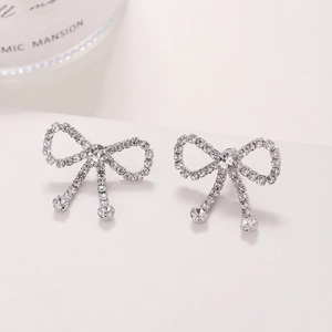 Sparkling silver bow knot earrings with pavé rhinestones and elegant tassels