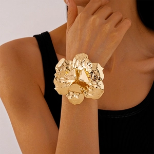 Fashionable golden irregular wrinkled flower open bangle shown on a model wrist