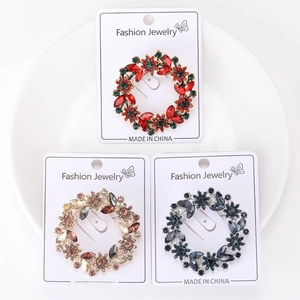 Detailed macro view of three sparkling crystal wreath brooches in assorted colors