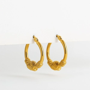 Detailed macro view of gold hoop earrings featuring sleek mirror polish and spiral textures