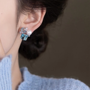 Elegant silver earrings with square blue zircon and white pearl shown on model