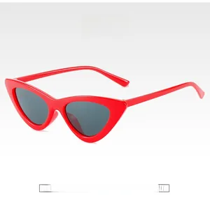 Detailed view of red cat-eye sunglasses with dark grey lenses and high-gloss frames