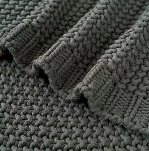 Close-up of dark grey knitted fabric showing intricate stitch texture and soft folds