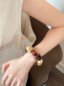 Detail of bohemian coconut shell and wood bead stretch bracelet on a female wrist
