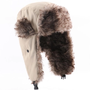 Detail of beige winter trapper hat with warm dark brown faux fur lining and black buckle