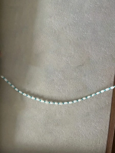 Détail de perles de riz blanches et perles turquoise sur un collier de perles minimaliste