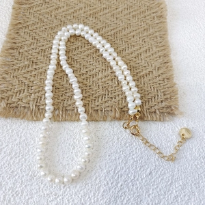 Detail view of natural freshwater pearls with golden lobster clasp and adjustable chain