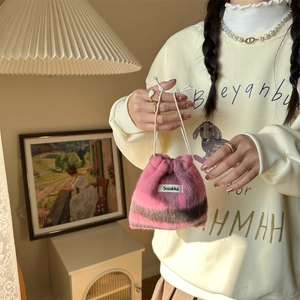 Detail of soft pink and brown plaid wool drawstring bag with fuzzy texture handheld