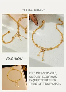 Detail of double-layer gold chain anklet featuring a crystal flower and tassel pendants