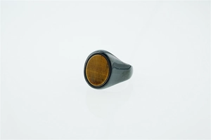 Macro detail of men's signet ring with round tiger eye stone on black polished band