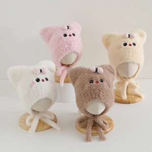 Close-up of plush baby earflap hats with cat ears and bow details in multiple colors