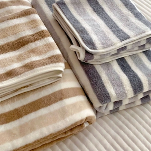 Macro detail of thick striped plush towels with soft texture and durable hemmed edges