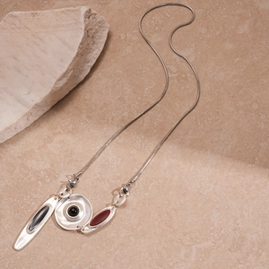 Collier métallique argenté avec pendentifs géométriques et gemmes rouges noires
