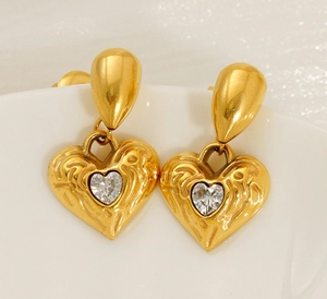 Macro shot of 18k gold heart earrings with hammered texture and sparkling center stone